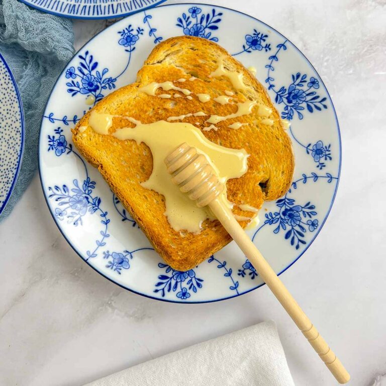 Whipped honey spread on a toasted bread using a honey stick.