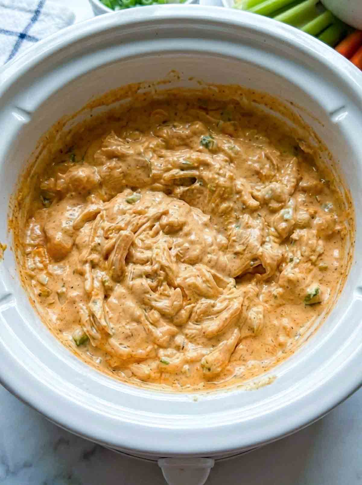 Buffalo chicken dip cooked in a crockpot.