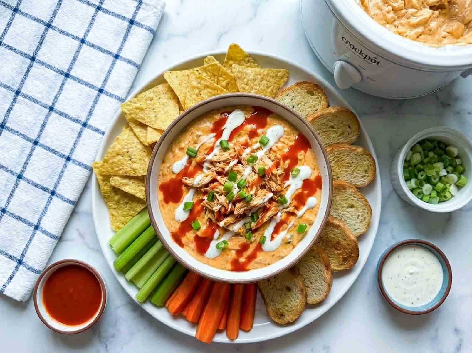 Buffalo chicken dip platter with chips, veggies, bread, and dipping sauces