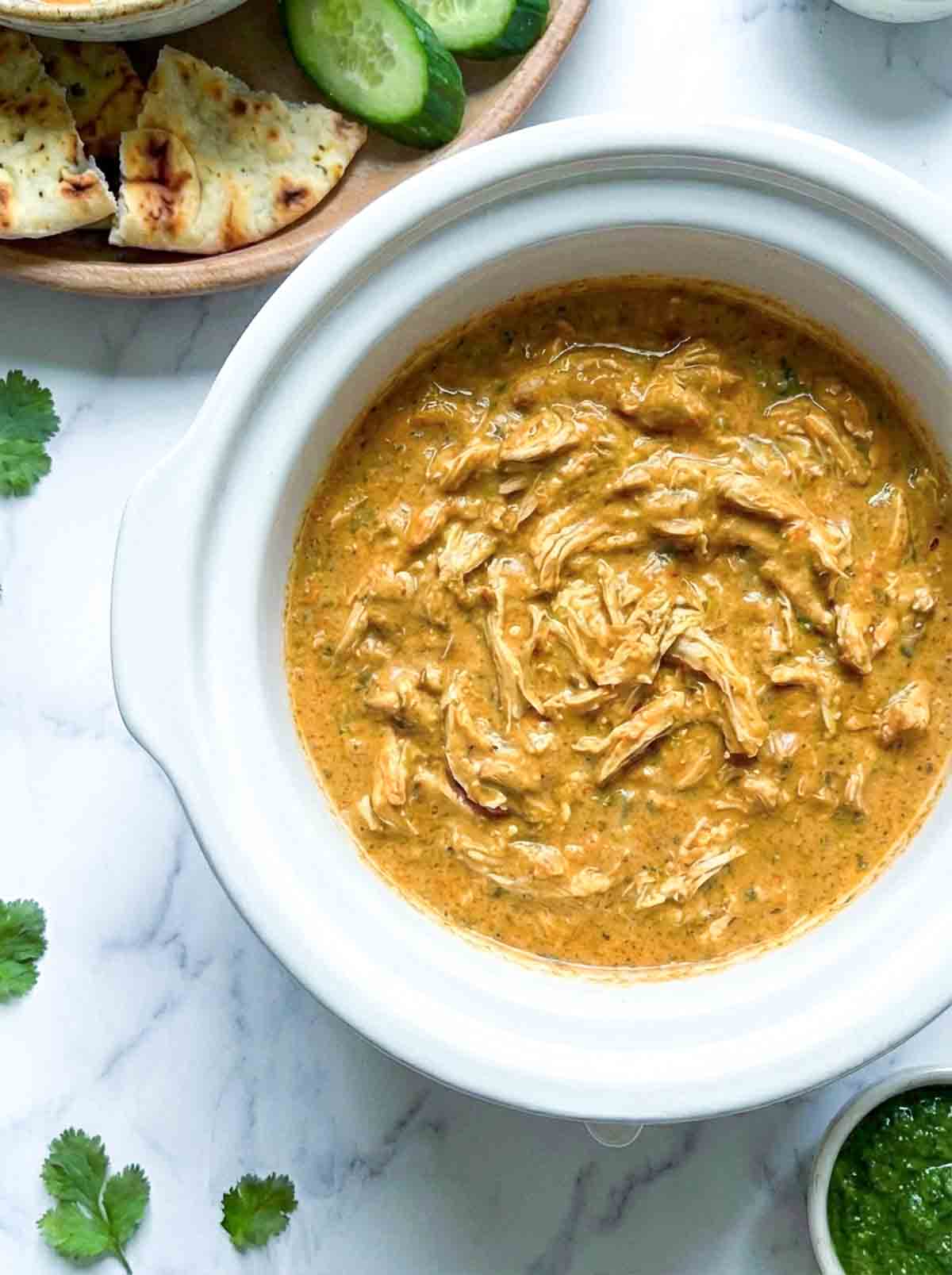 Close up of the crockpot with butter chicken dip inside.