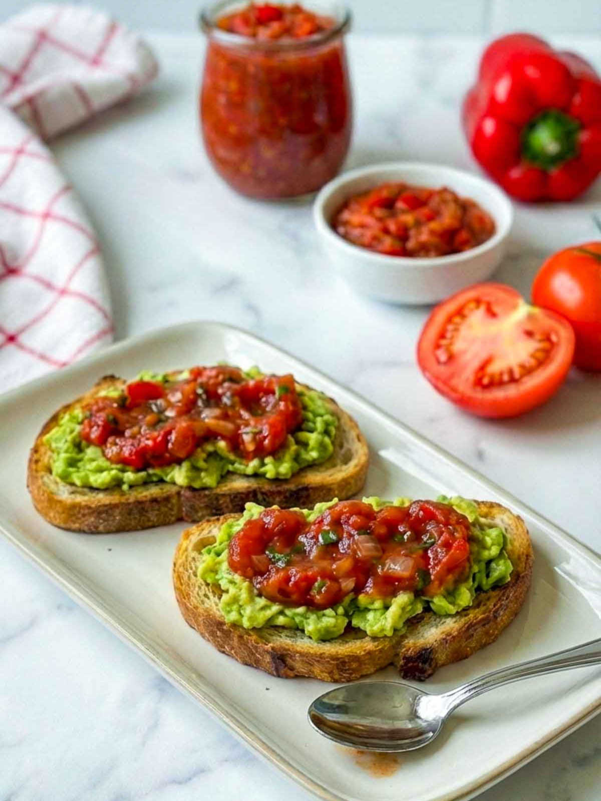 Tomato pepper relish on avocado toast on sourdough bread.